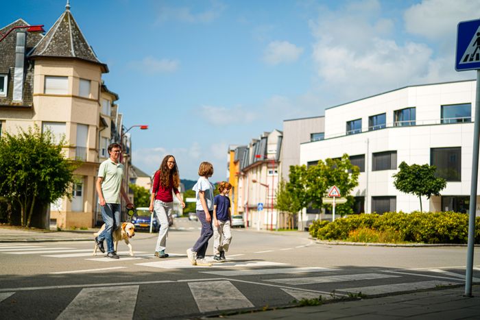 Eine Familie überquert die Straße beim Wandern