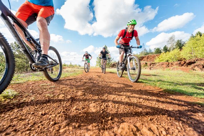 Group of mountainbikers ride accross rocky, red terrain